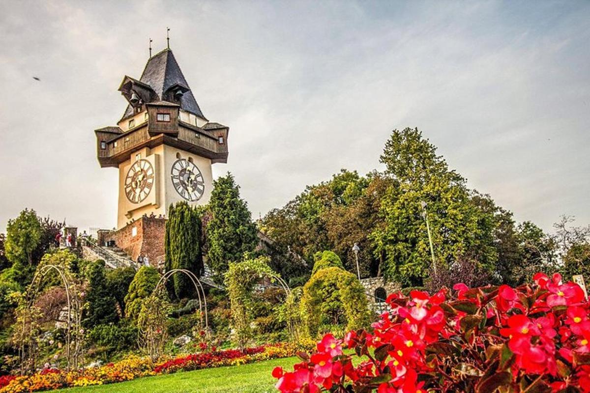 a clock tower in the middle of a park with flowers