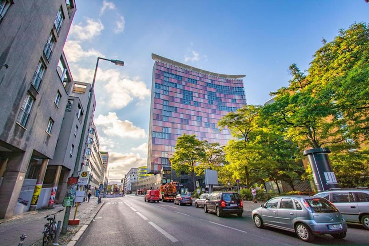 jalan kota dengan mobil-mobil yang diparkir di depan gedung tinggi