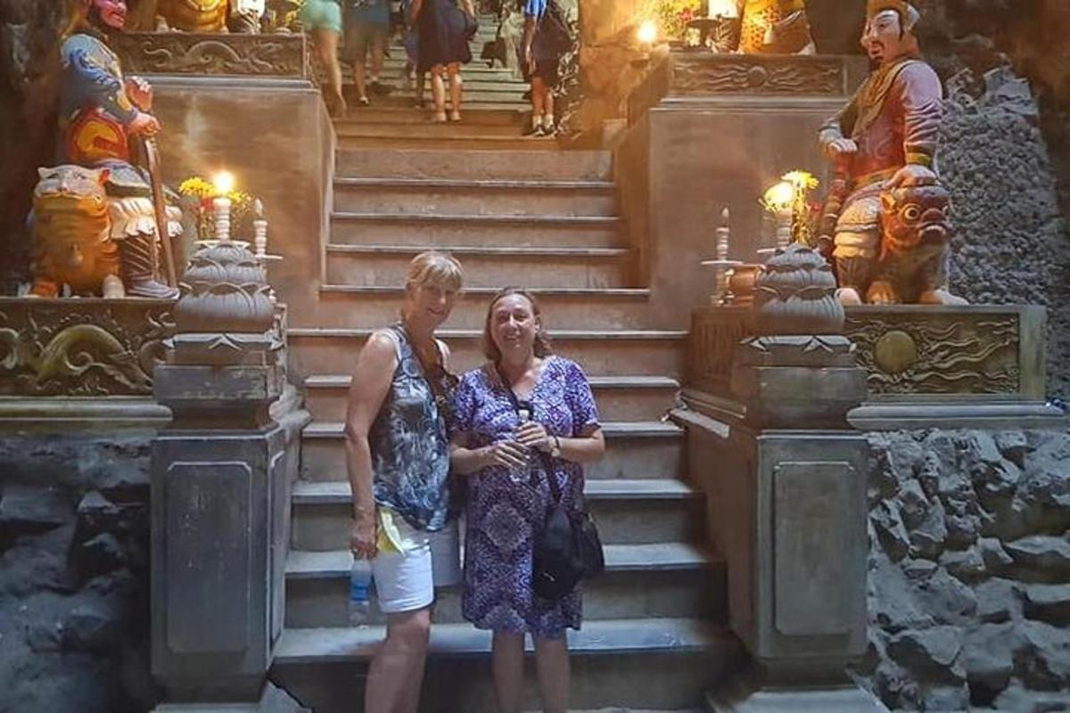 duas mulheres em pé nas escadas em frente a um templo