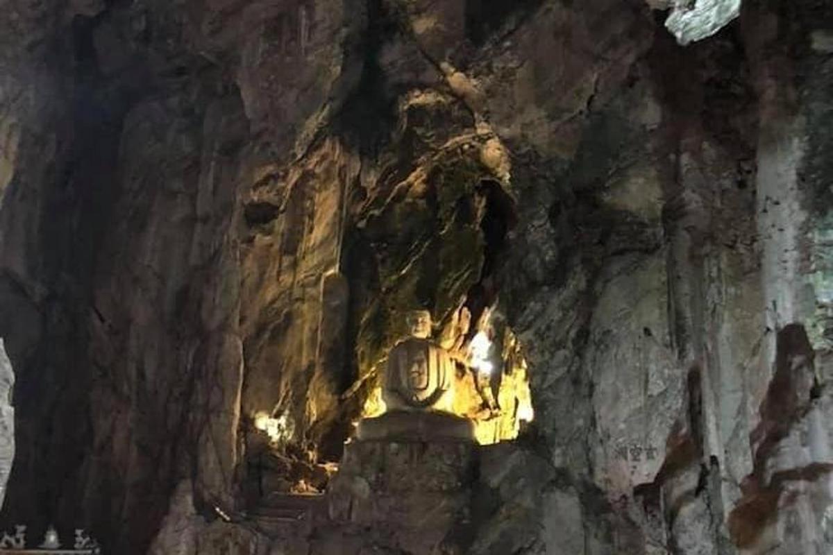 una grotta con una statua su una parete rocciosa