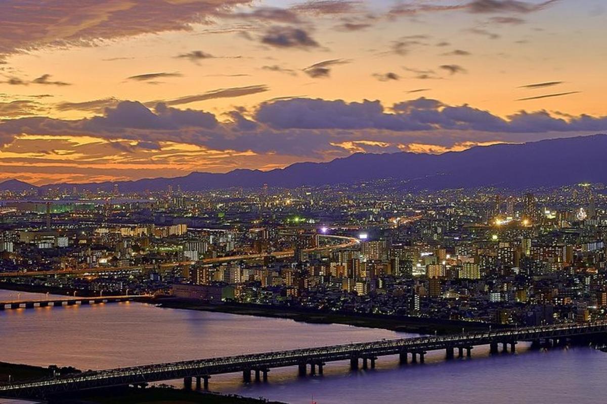 una vista di una città con un ponte al tramonto