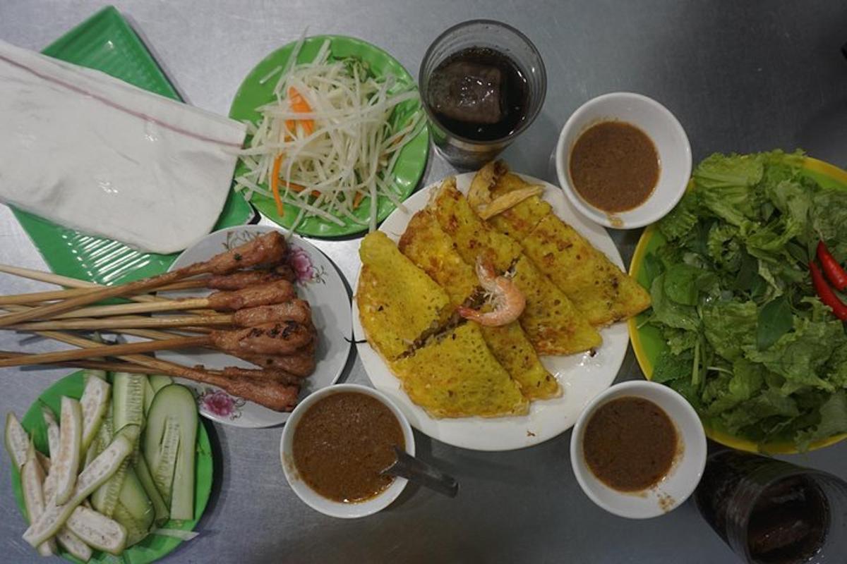 uma mesa com pratos de comida e tigelas de molho para mergulhar
