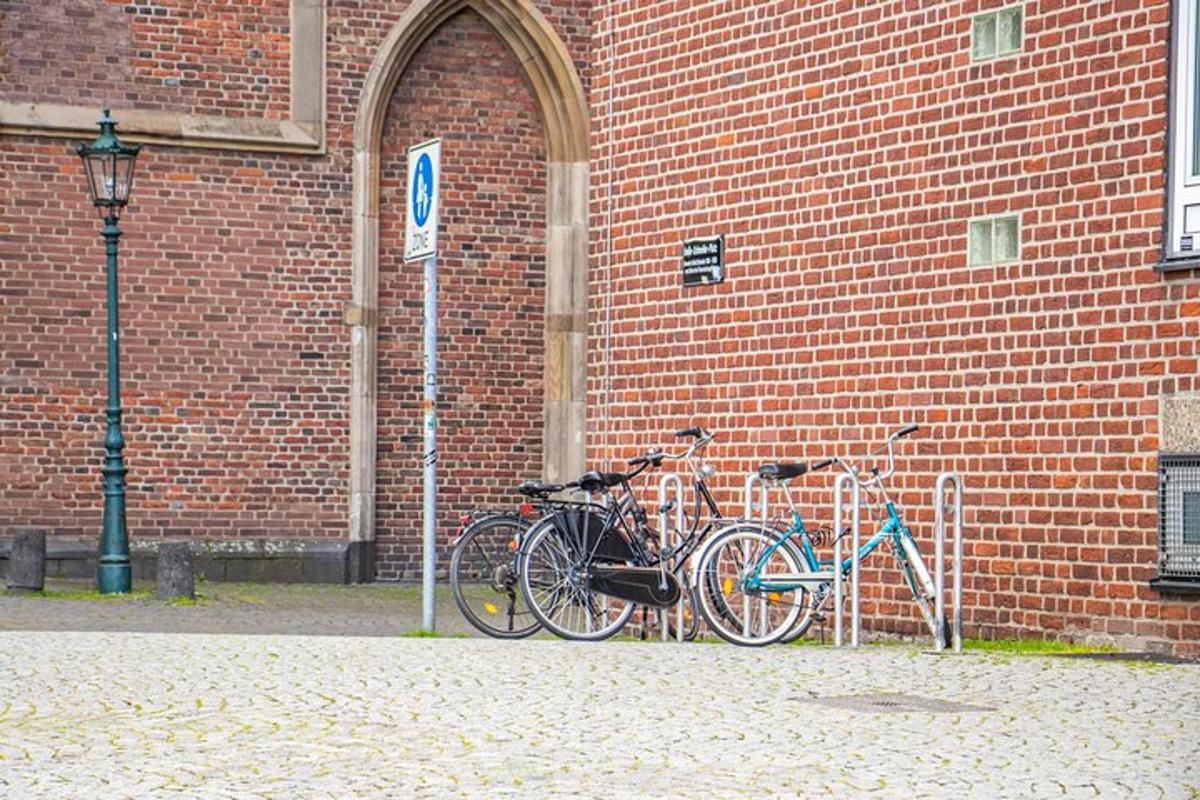 kaksi polkupyörää pysäköitynä tiiliseinän viereen