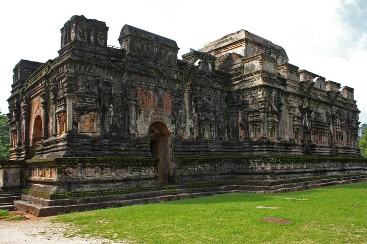một tòa nhà đá cũ có cỏ ở phía trước
