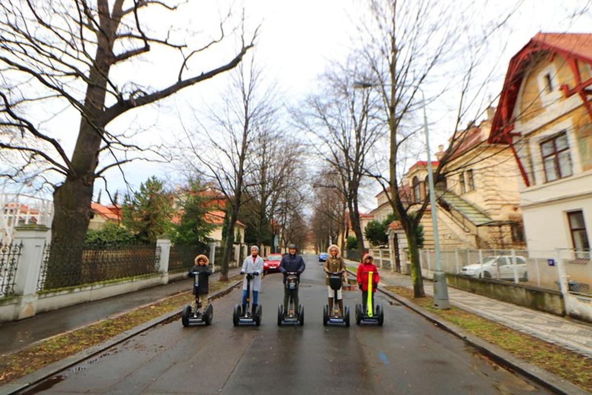 skupina lidí jedoucích na koloběžkách po ulici