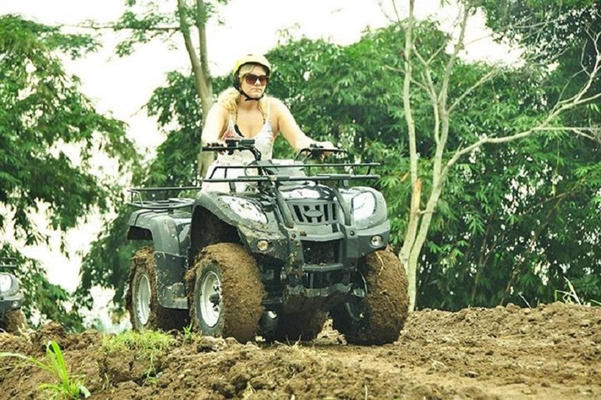 seorang lelaki menaiki atv di jalan tanah
