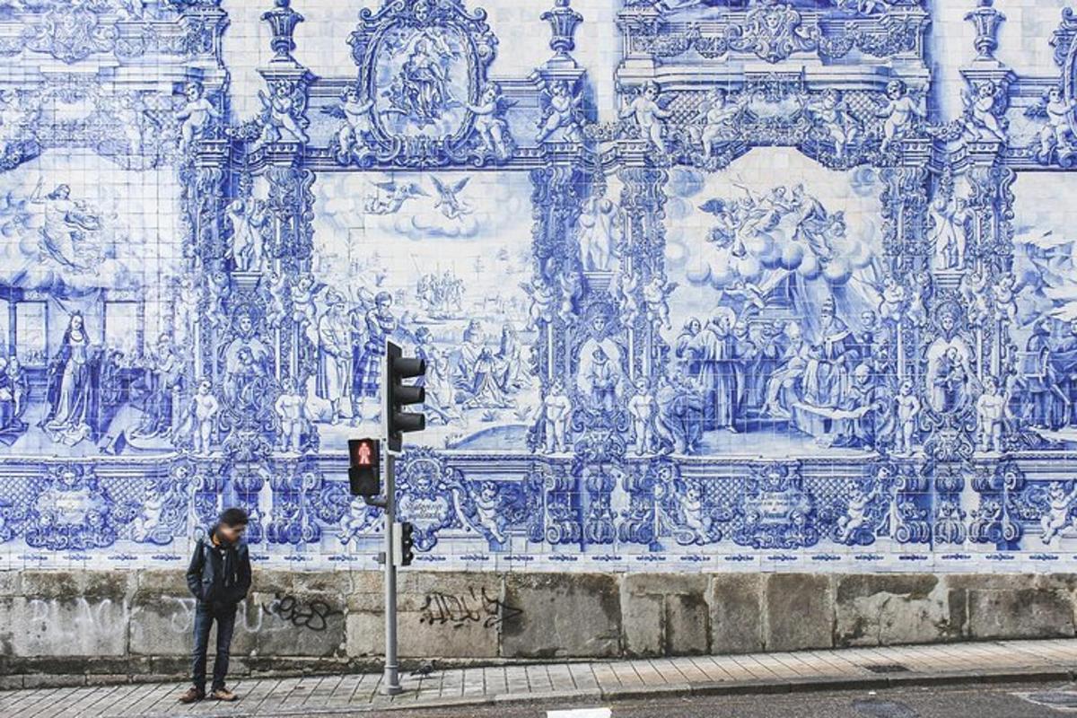 uma pessoa parada ao lado de um semáforo em frente a um prédio
