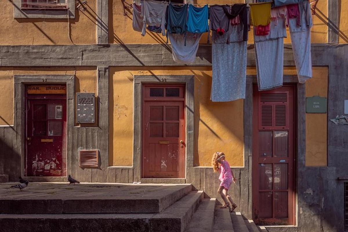 uma garotinha descendo as escadas em frente a um prédio