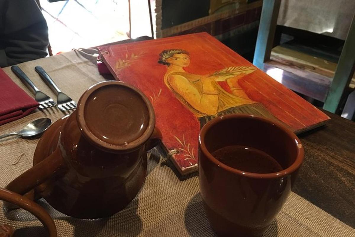 cawan kopi dan lukisan seorang wanita di atas meja