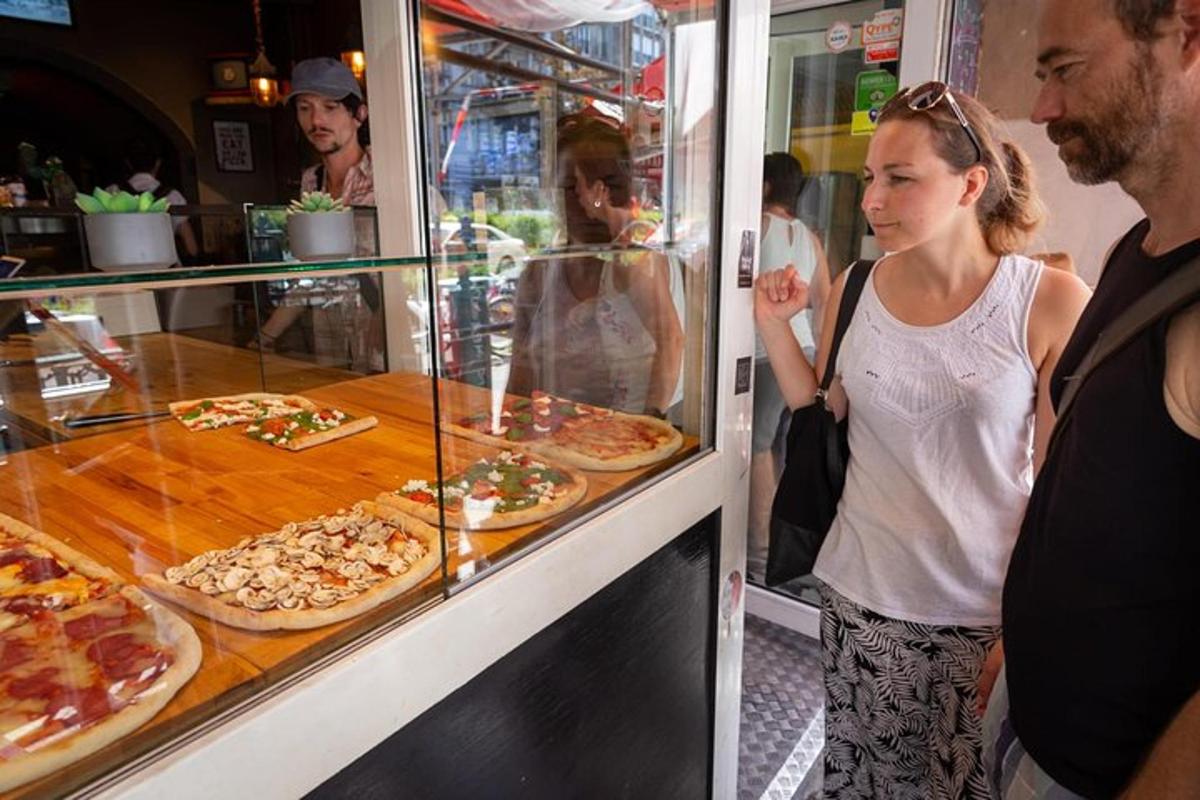 Una mujer parada frente a una pizzería