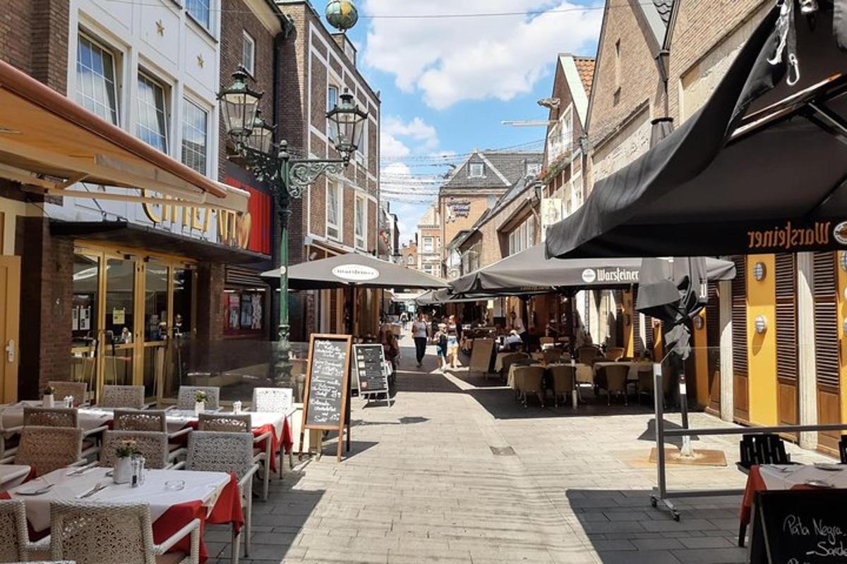 una calle vacía con mesas, sillas y sombrillas