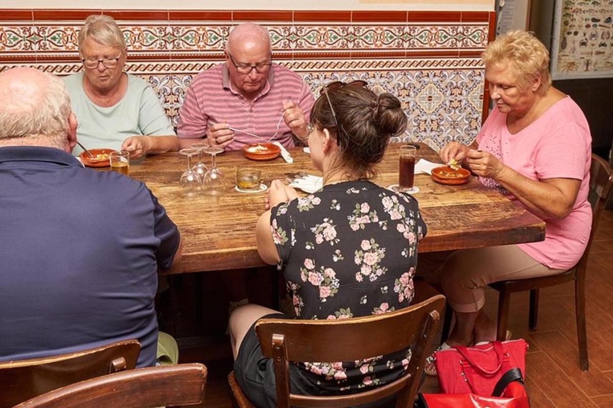 eine Gruppe von Menschen sitzt um einen Holztisch