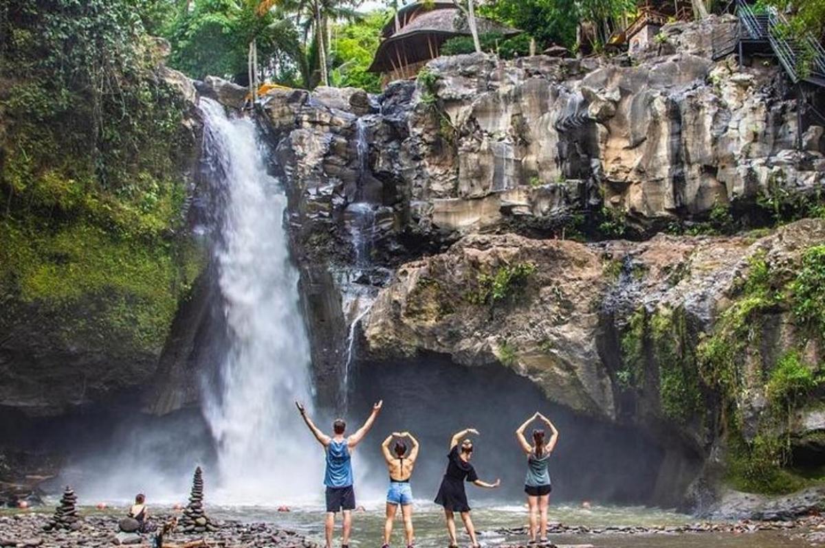 un gruppo di persone in piedi davanti a una cascata
