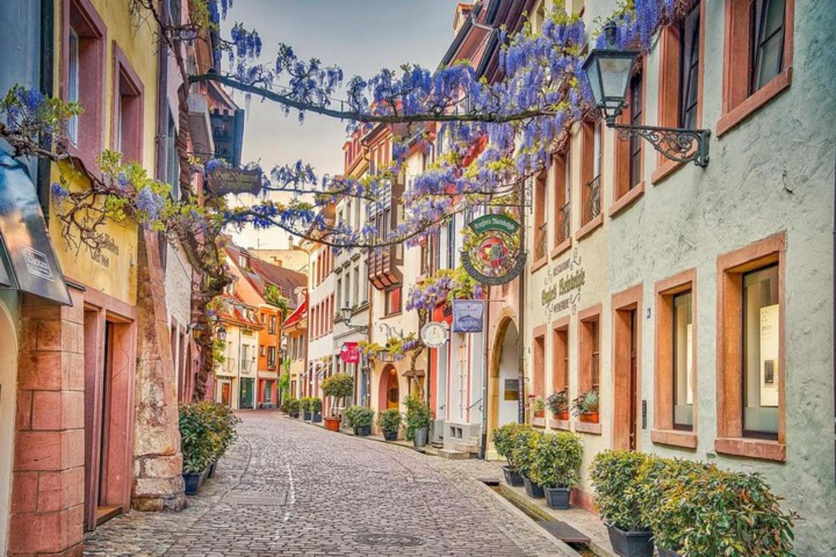 a narrow street with flowers hanging from buildings