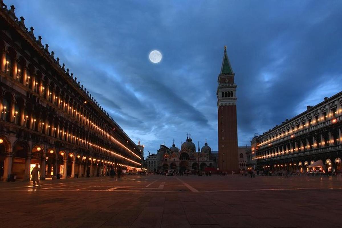 Un edificio con una torre de reloj con una luna en el cielo.