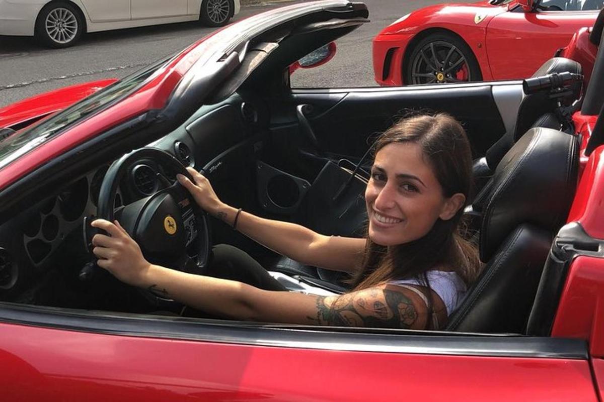 žena sedící na sedadle řidiče červeného auta