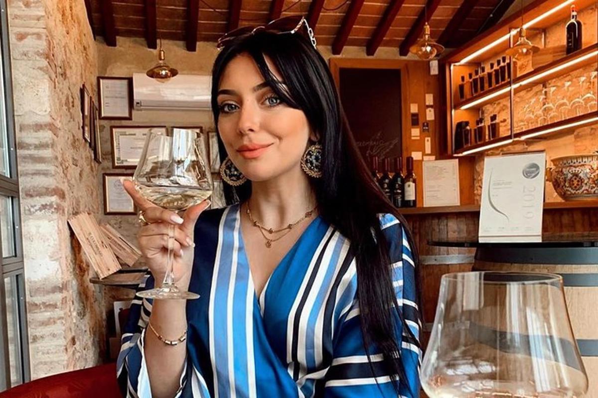 una donna tiene in mano un bicchiere di vino