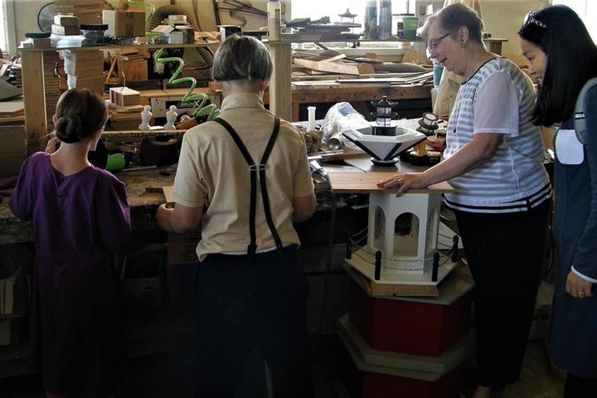 a group of people standing around a machine in a workshop