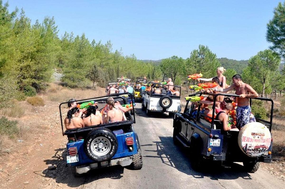 skupina ljudi, ki se vozijo v džipih po makadamski cesti