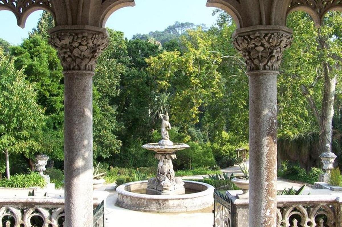 uma fonte em um jardim com árvores ao fundo