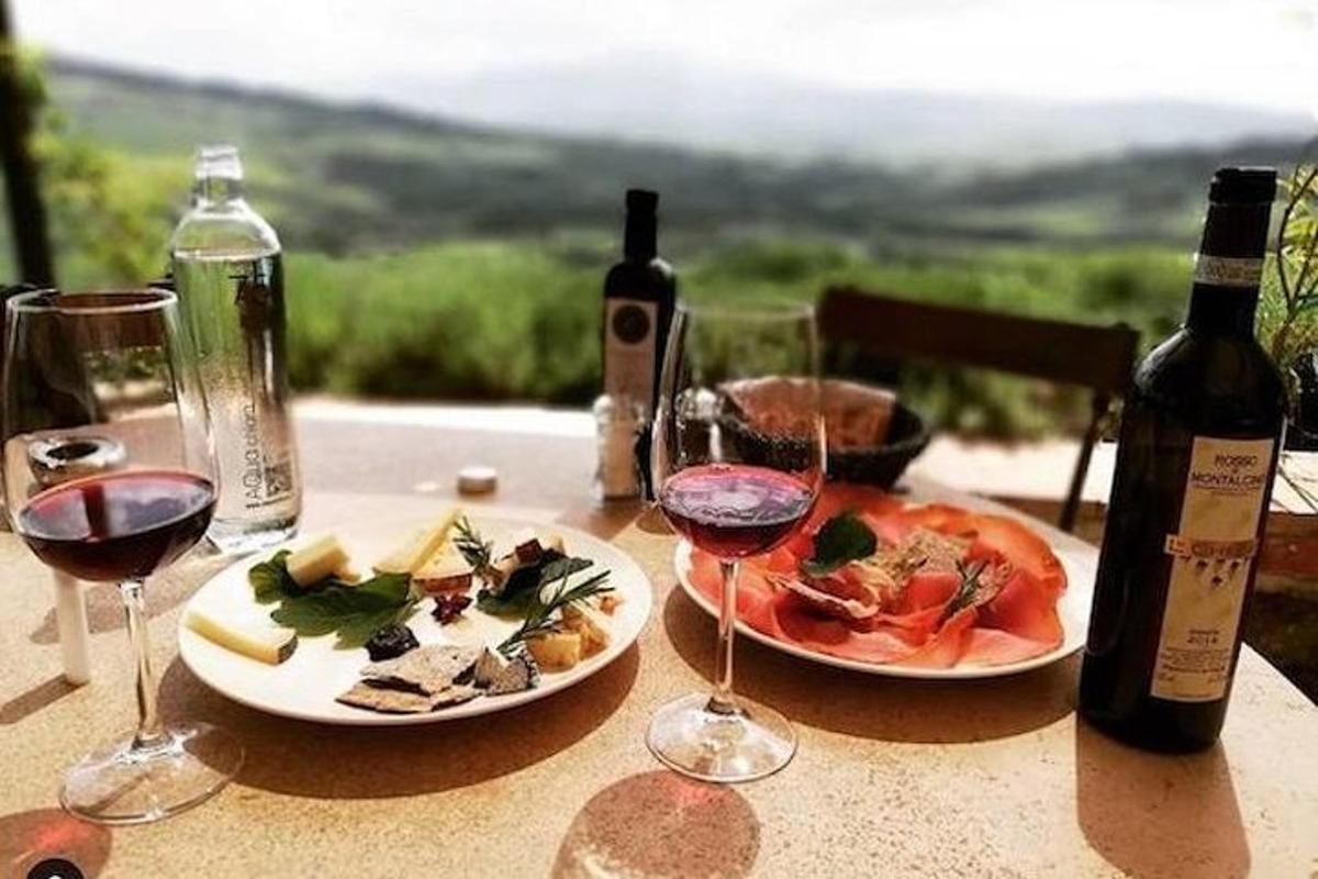 ένα τραπέζι με δύο πιάτα με φαγητό και ποτήρια κρασιού
