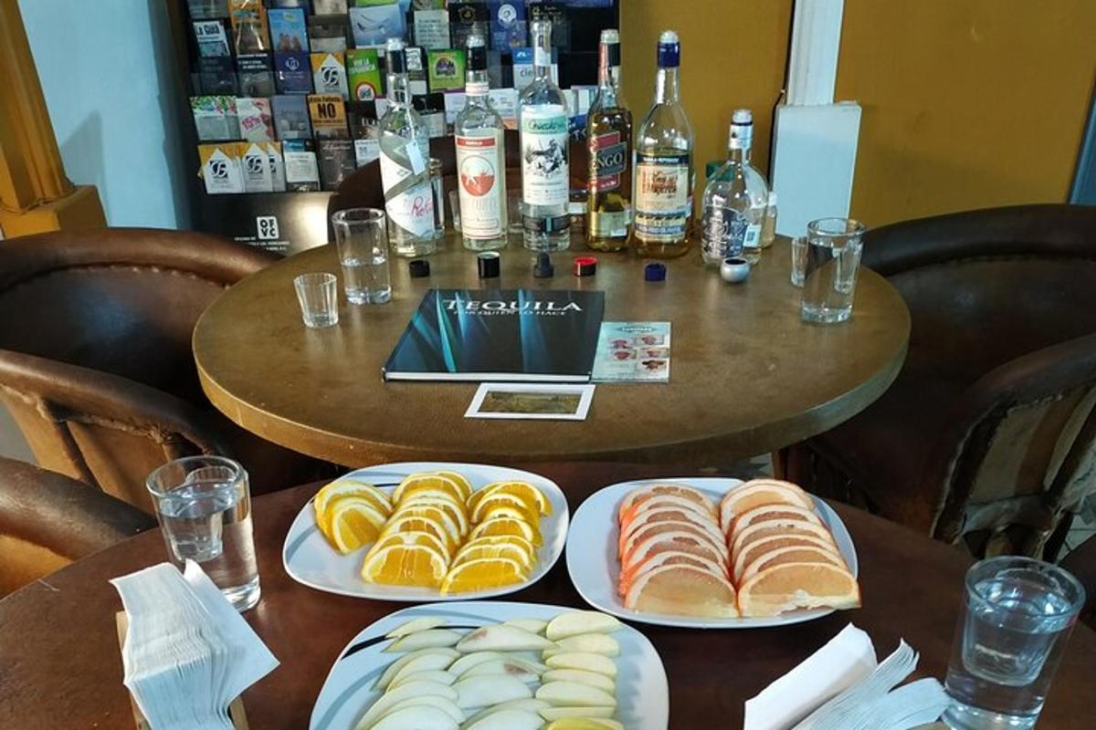 a table with plates of food and bottles of alcohol