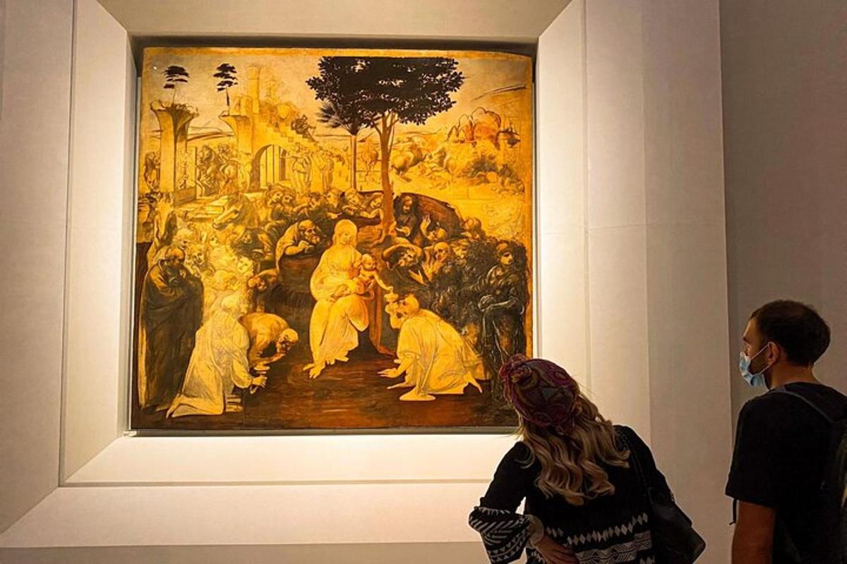 un gruppo di persone che guardano un dipinto in un museo