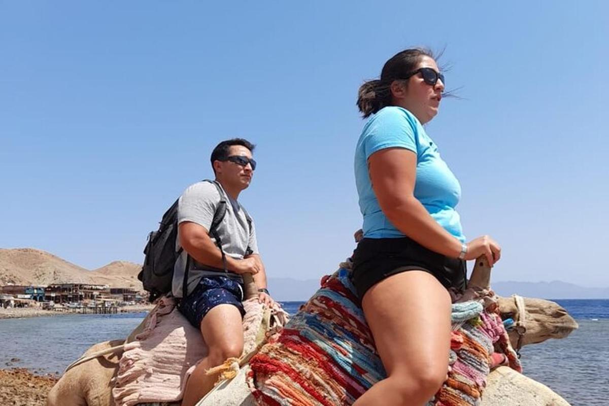 Un hombre y una mujer sentados en las rocas junto al agua