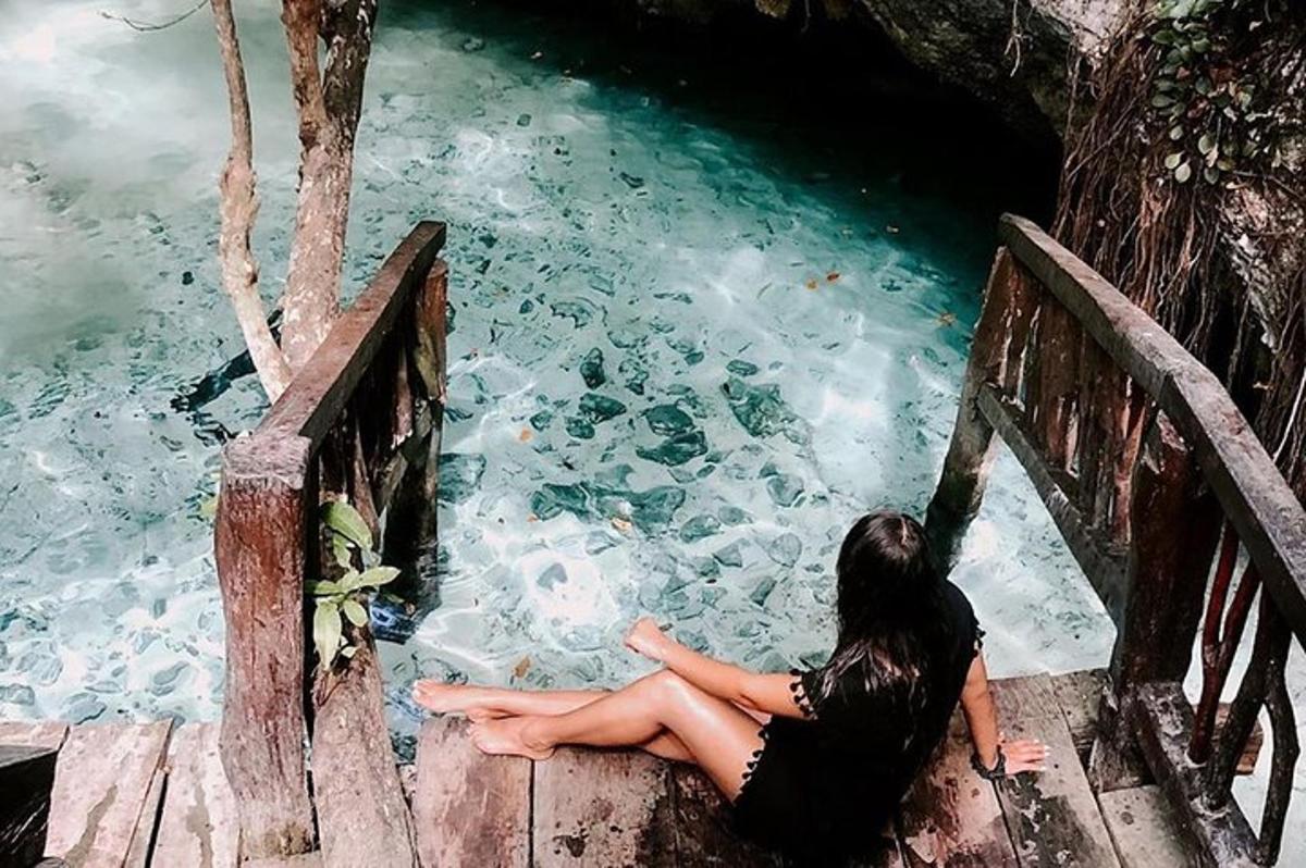 una donna seduta su un ponte che guarda l'acqua