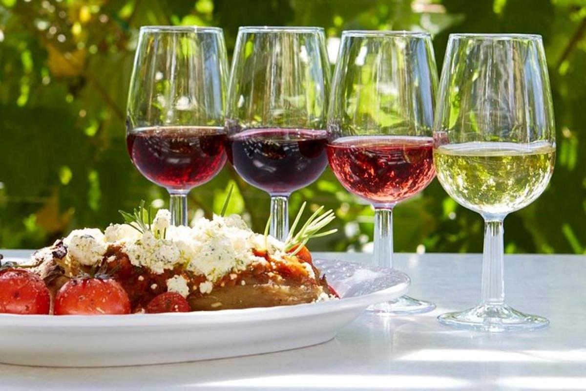 um prato de comida e taças de vinho sobre uma mesa