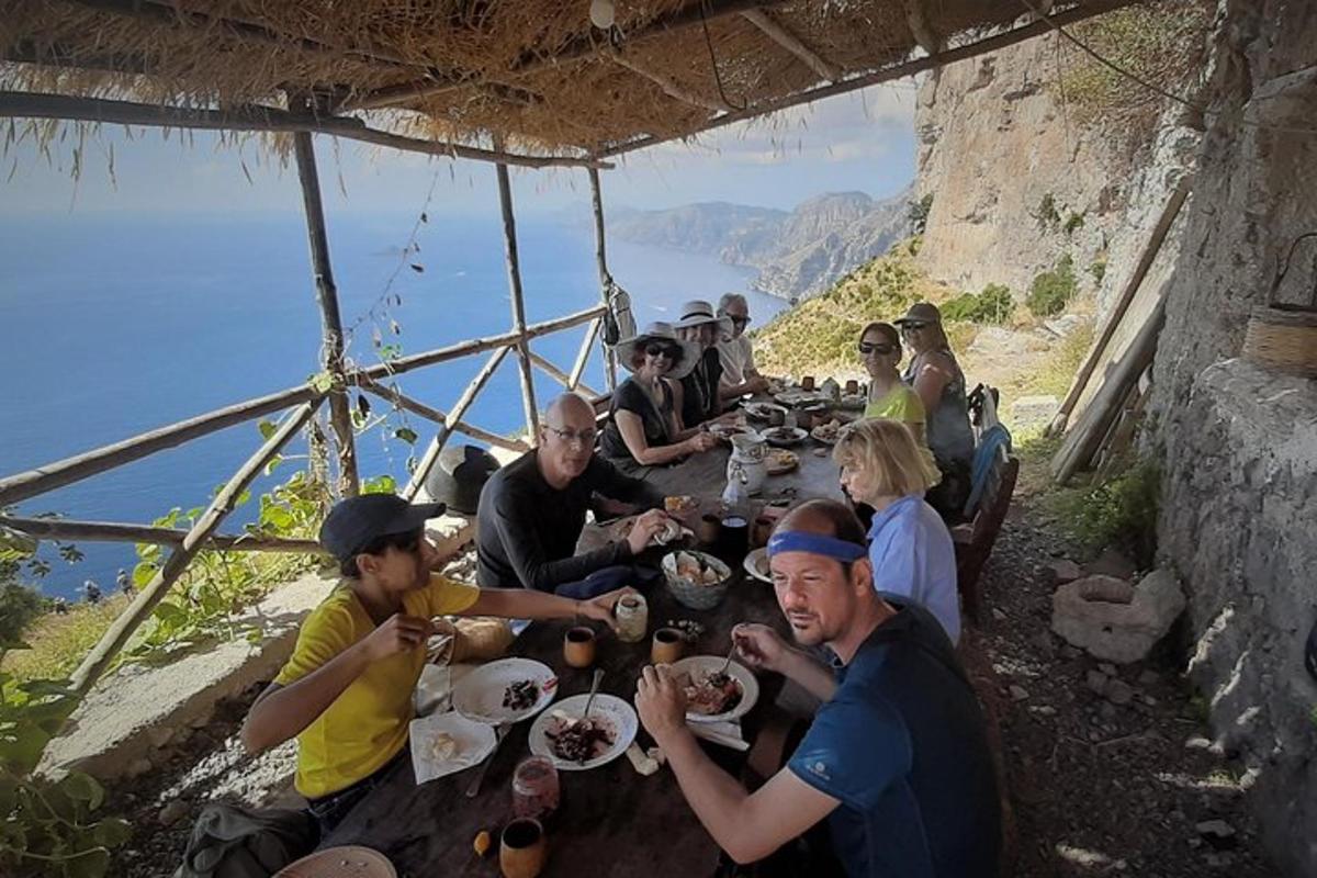 um grupo de pessoas sentadas ao redor de uma mesa comendo comida