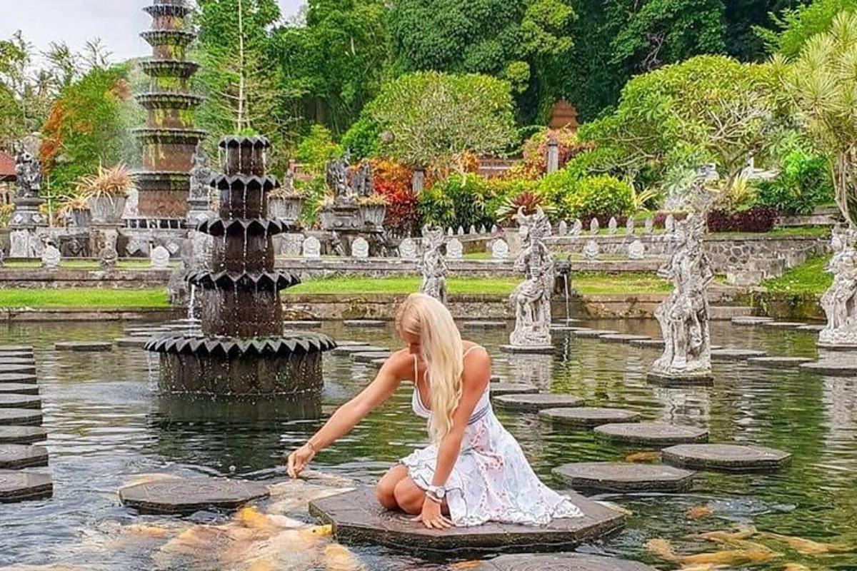 una donna in abito seduta nell'acqua di una fontana