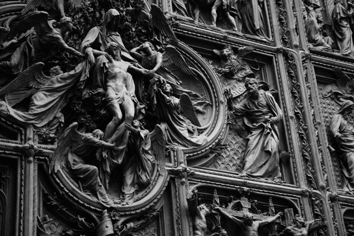 una porta di legno con un gruppo di statue sopra