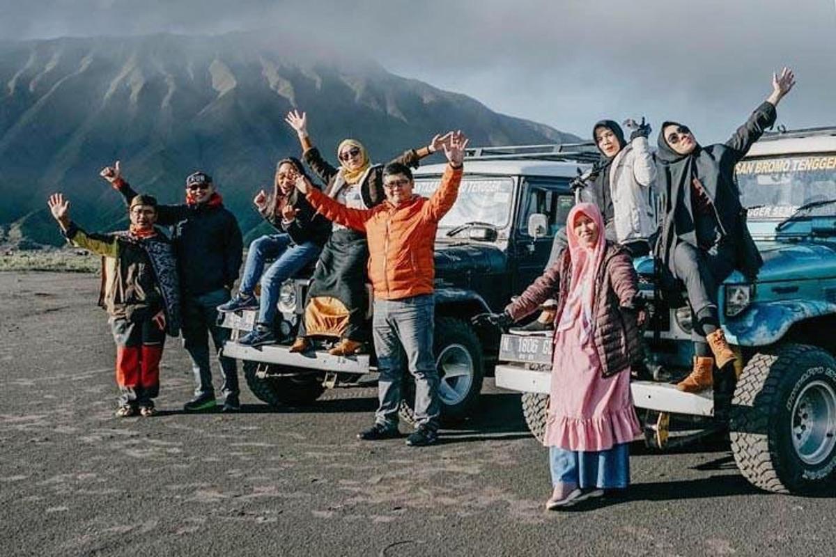 een groep mensen die achterop een vrachtwagen zitten