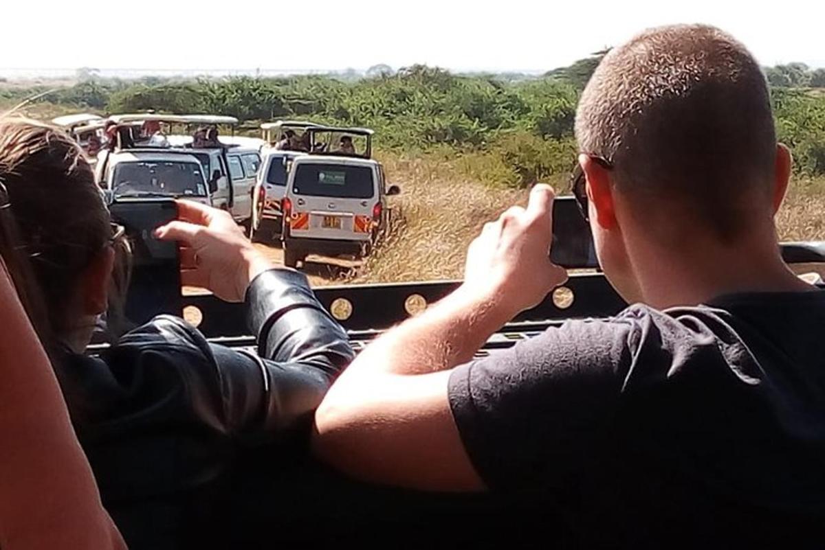 a group of people in a vehicle taking pictures of vehicles