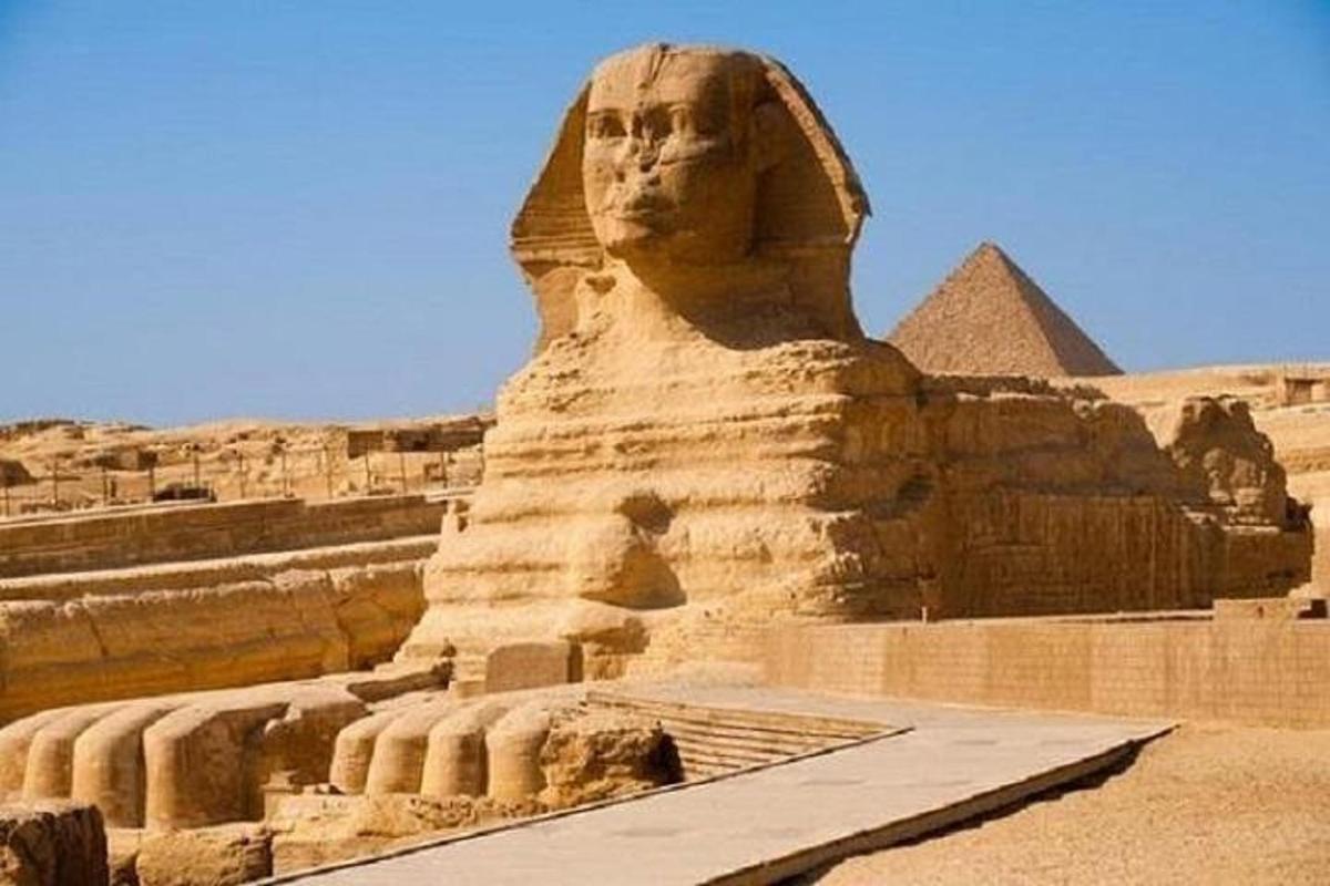 a statue of the sphinx in front of the pyramids