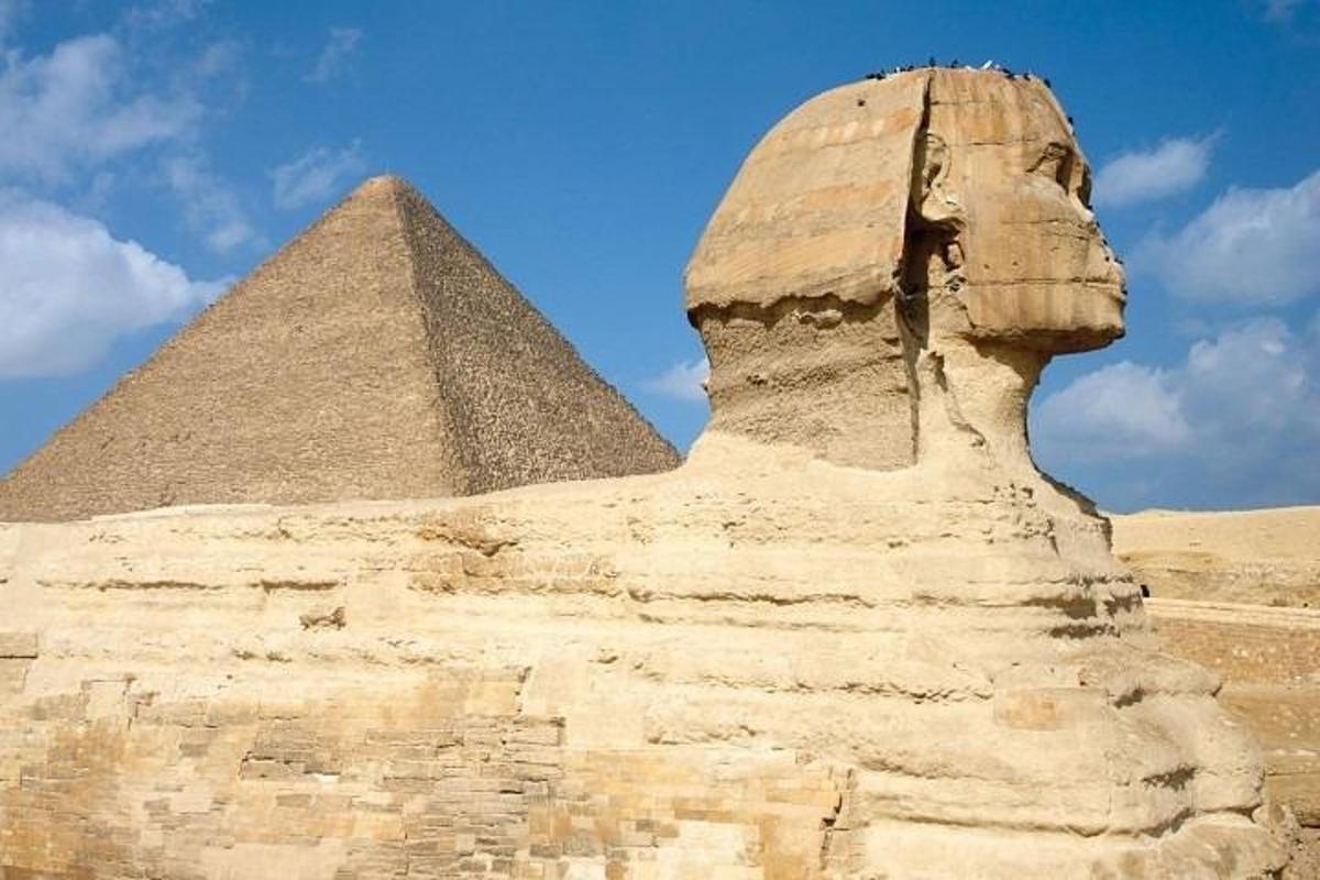 una estatua frente a la esfinge y la pirámide