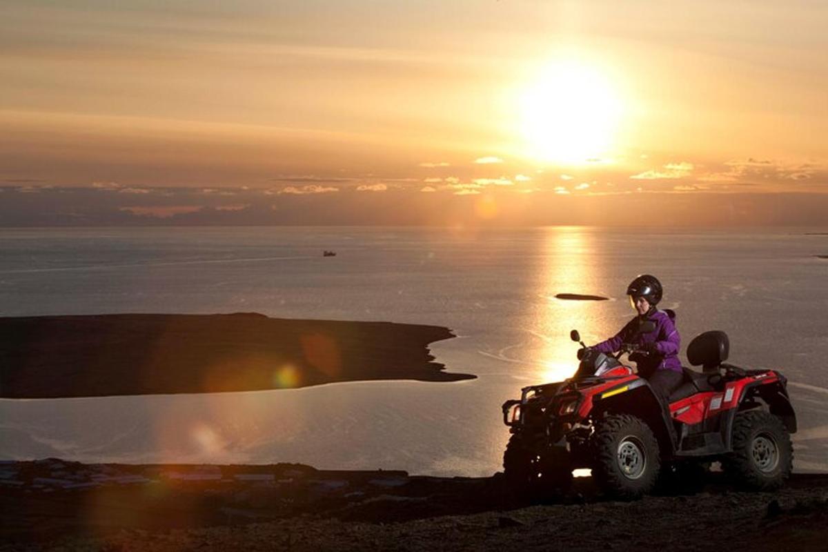 seseorang di atas atv yang diletakkan di atas bukit dengan matahari terbenam
