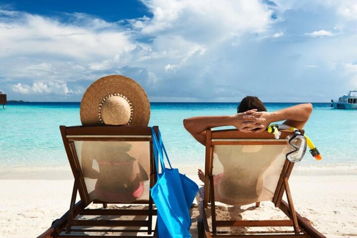 to personer sitter i stoler på en strand
