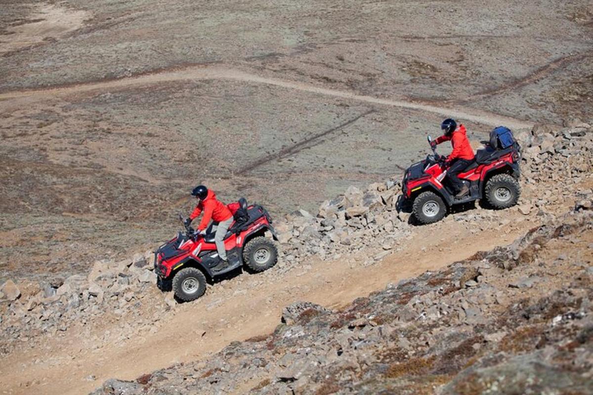 kaks inimest sõidavad ATV-dega kivisel mäel