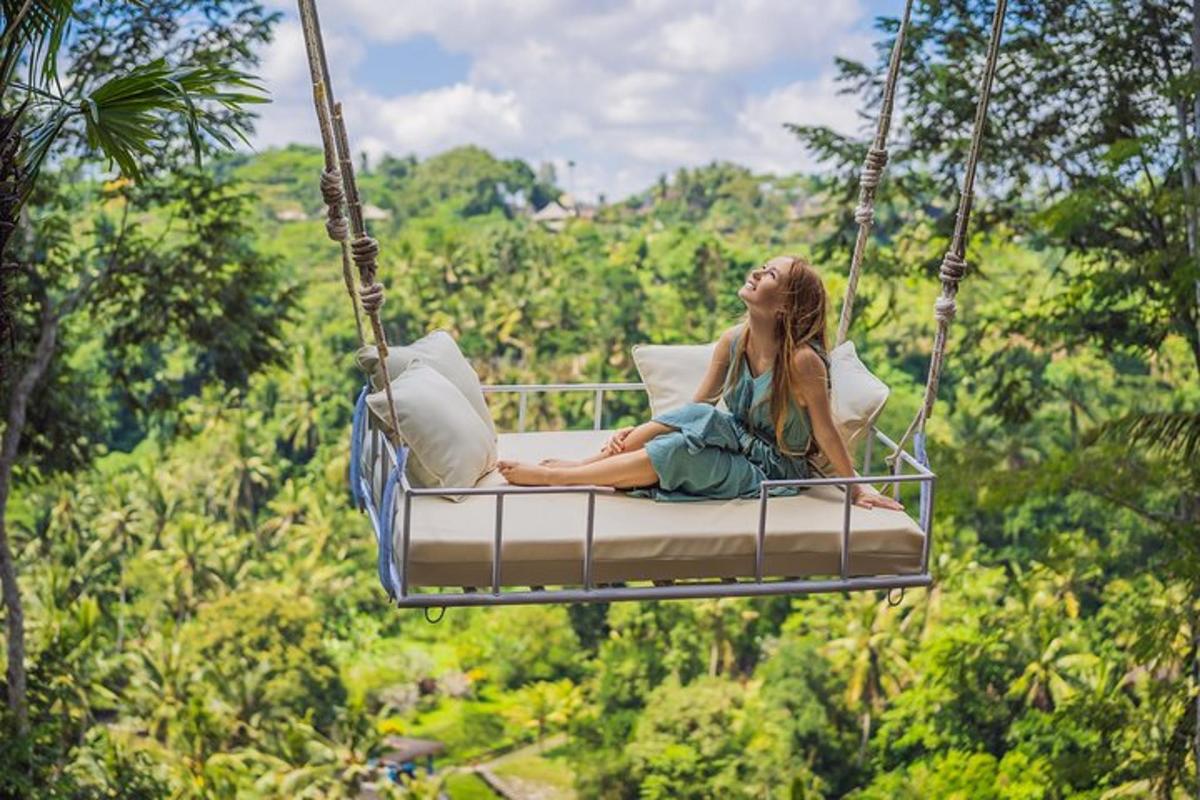 a woman sitting on a swing in the jungle