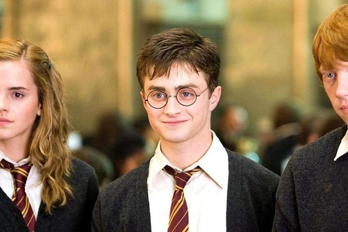 un jeune homme portant des lunettes debout entre deux femmes