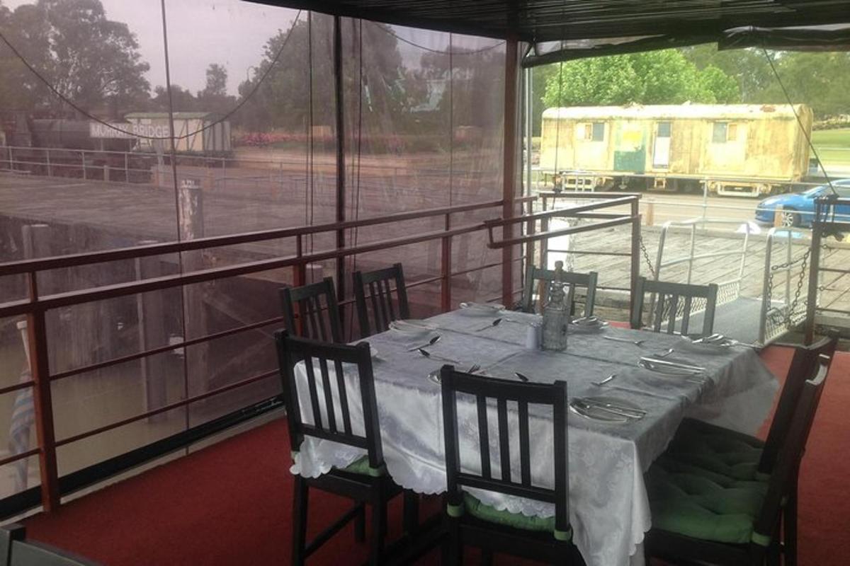 Una mesa y sillas en una habitación con vista a una cancha de tenis.