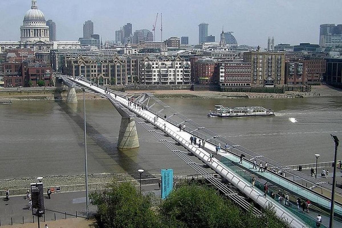 un pont sur une rivière avec une ville en arrière-plan