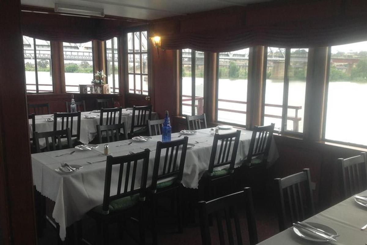 Un comedor con una mesa con mantel blanco.