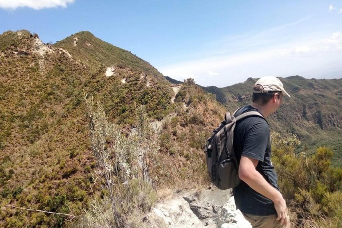 um homem com uma mochila em pé no topo de uma montanha