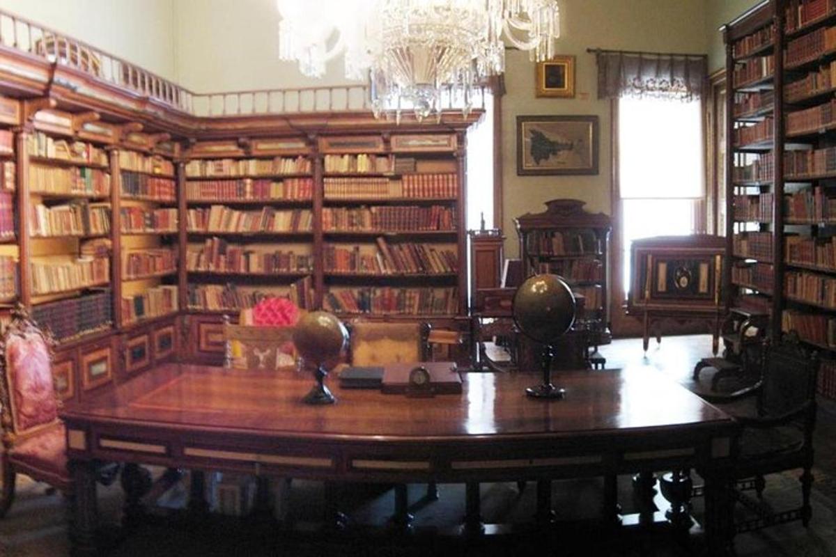 una biblioteca amb una taula i prestatgeries de fusta
