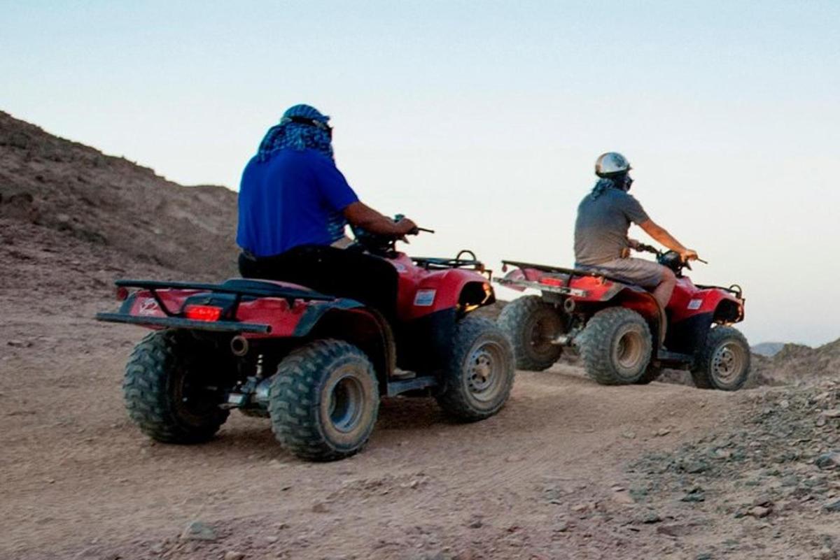 Dos personas viajando en vehículos todo terreno por un camino de tierra