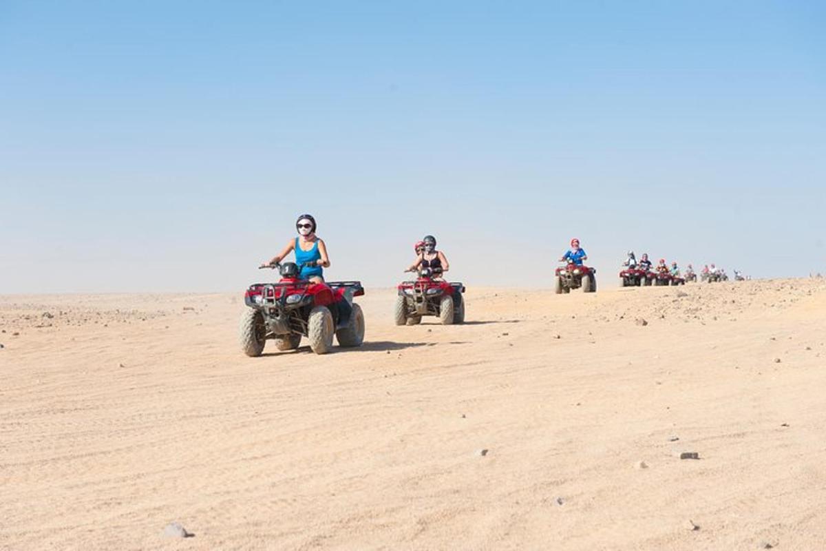 um grupo de pessoas andando de quadriciclo no deserto