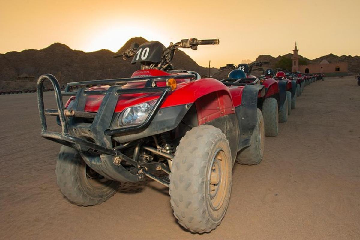 um quadriciclo vermelho estacionado no deserto